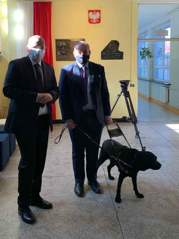 Fotografia: W holu głównym dyrektor Marcin Dębski i minister Paweł Wdówik z psem asystującym